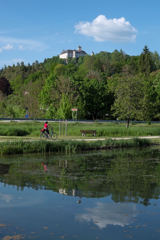 Heiligenstadt_SchlossGreifenstein-mit-Radler-am-See-hoch01_GK-2021